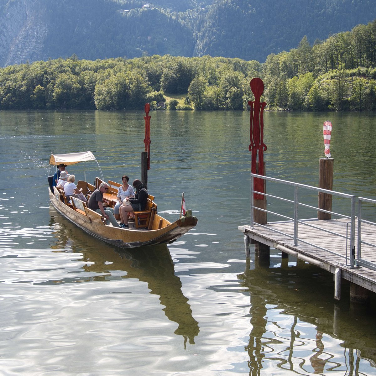 Traditional boat arriving beside Seecafé’s landing on Lake Hallstatt